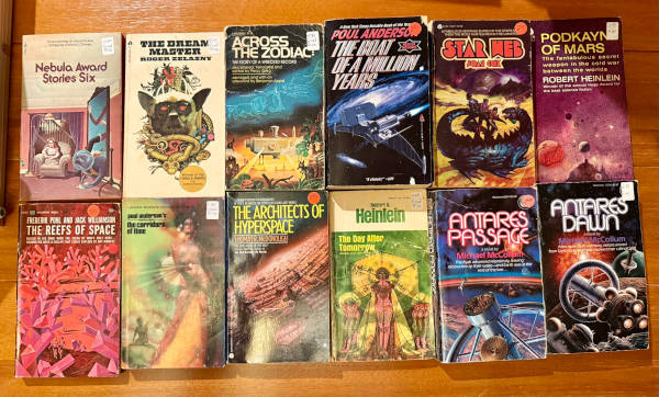science fiction novel used book haul showing 10 various classic books, including Asimov and Heinlein, set on a table